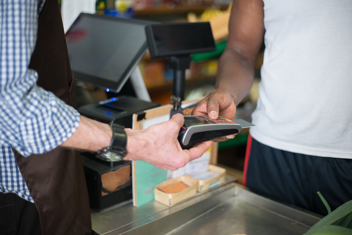 Cliente pagando com cartão na maquininha no ponto de venda